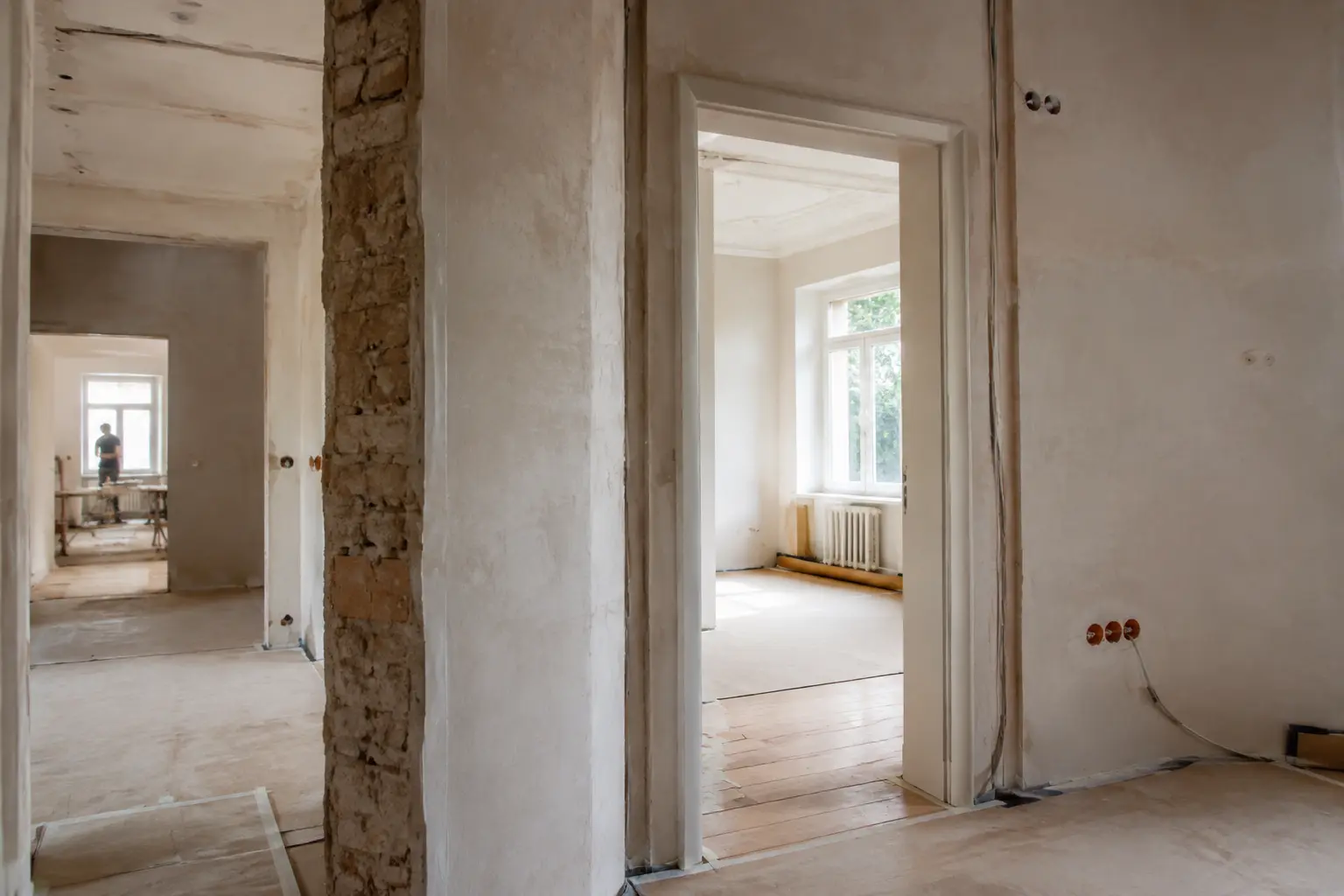 Wohnungssanierung im Bestand mit neuen Putzflächen und freigelegtem Mauerwerk vor dem Innenausbau